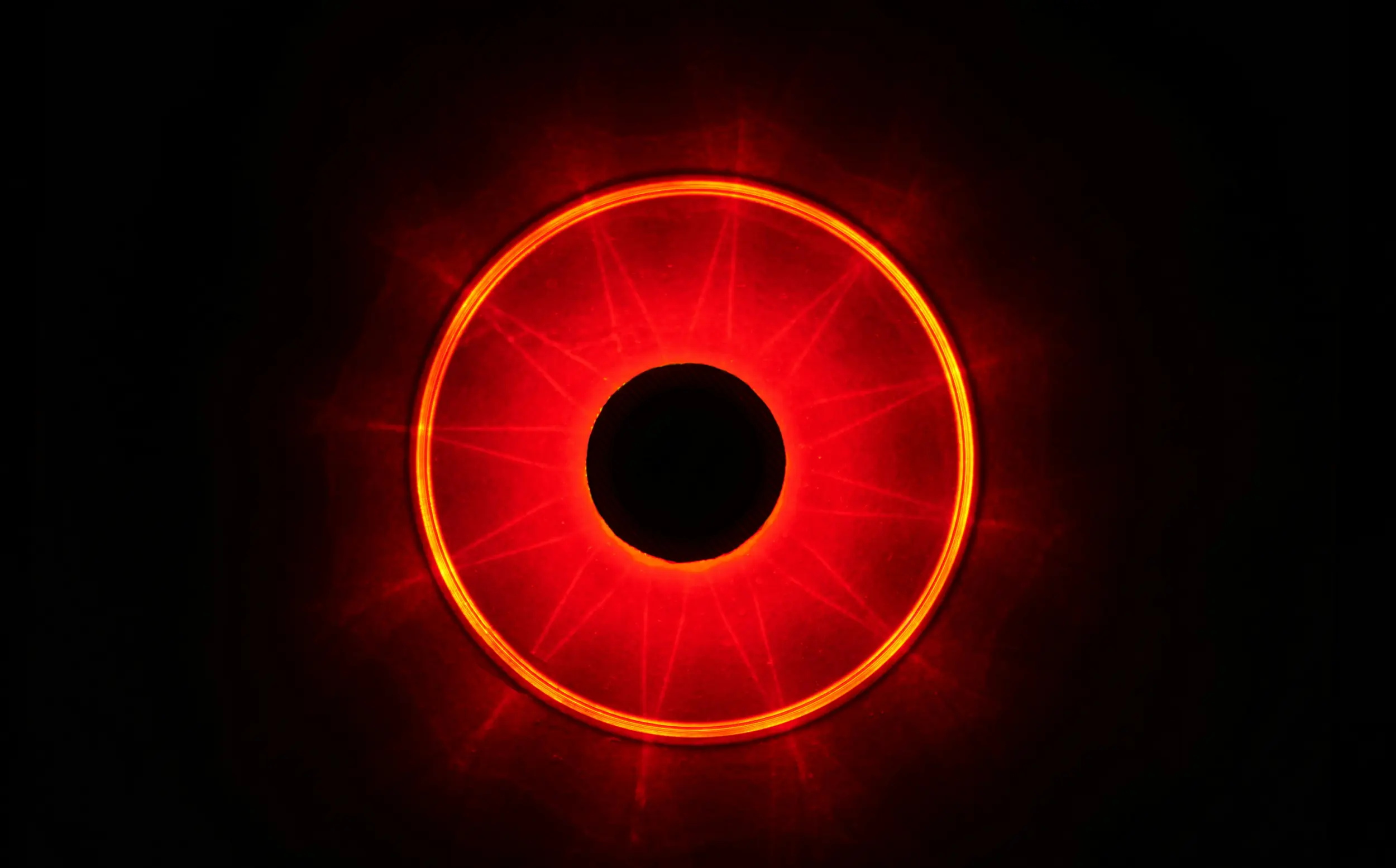 Image of a red circle of light that resembles a human iris over a black background.