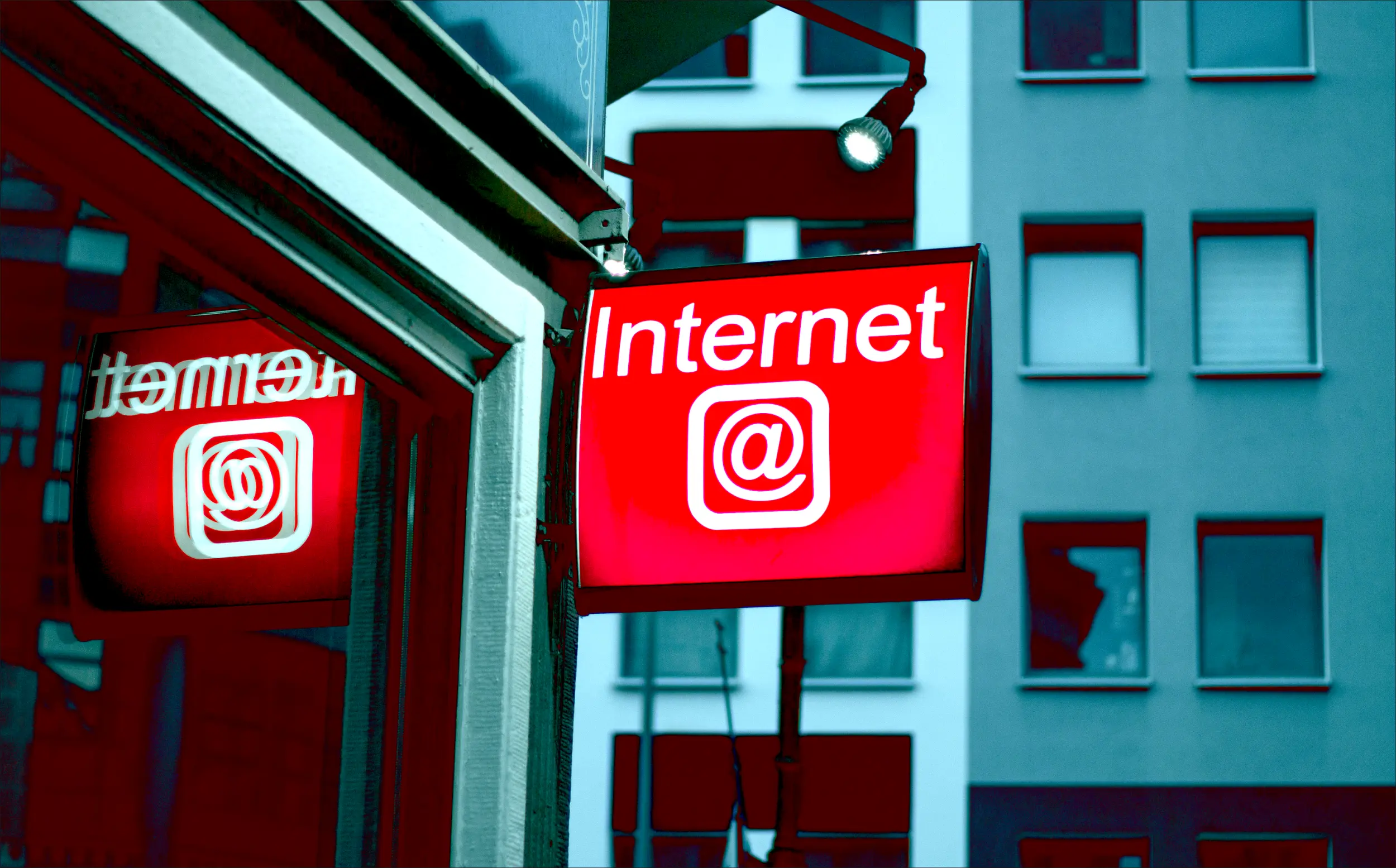 Photo of an illuminated red street sign with the word Internet on it.