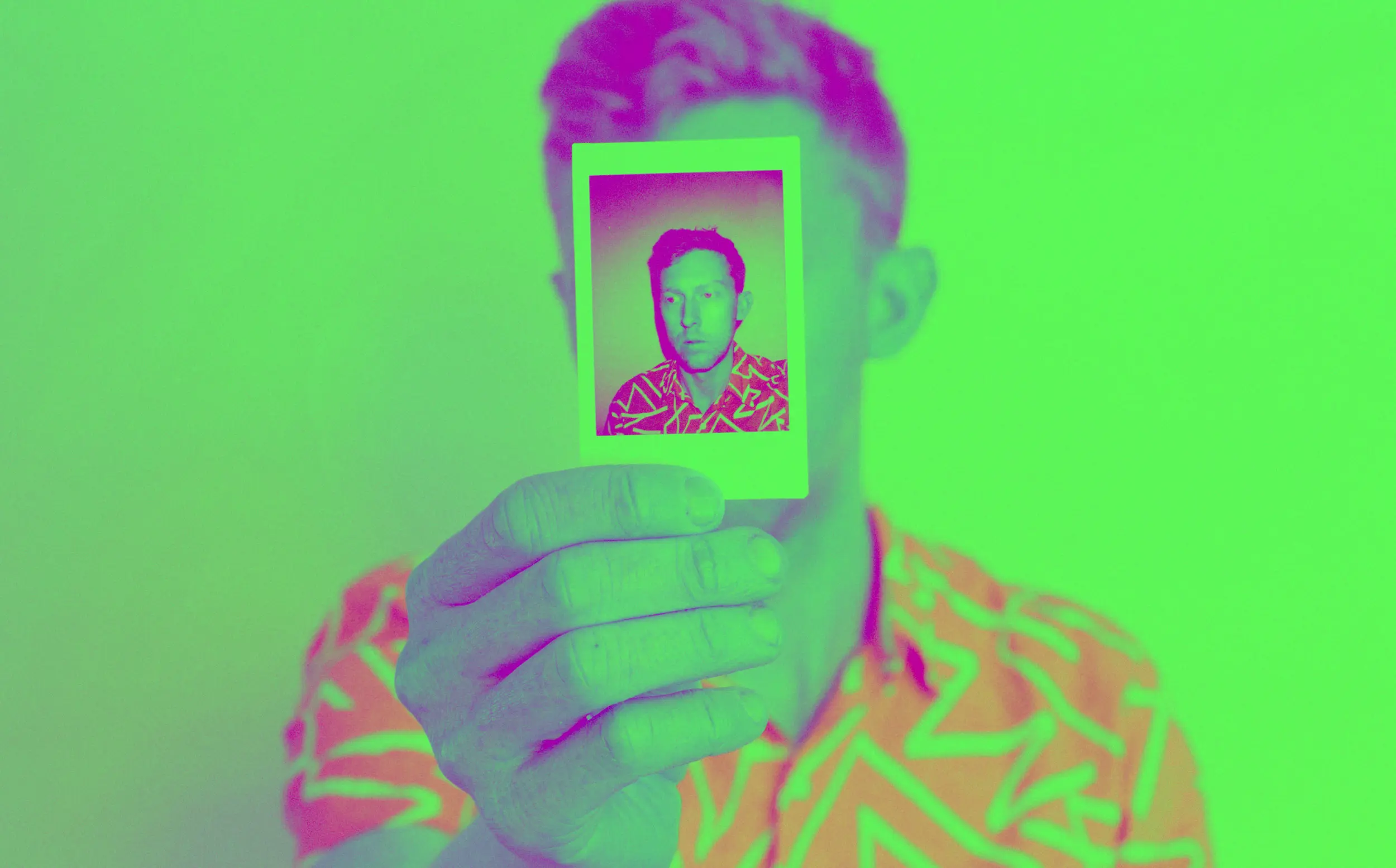 A stylized photo showing a person holding a printed photo of their face in front of their actual face.